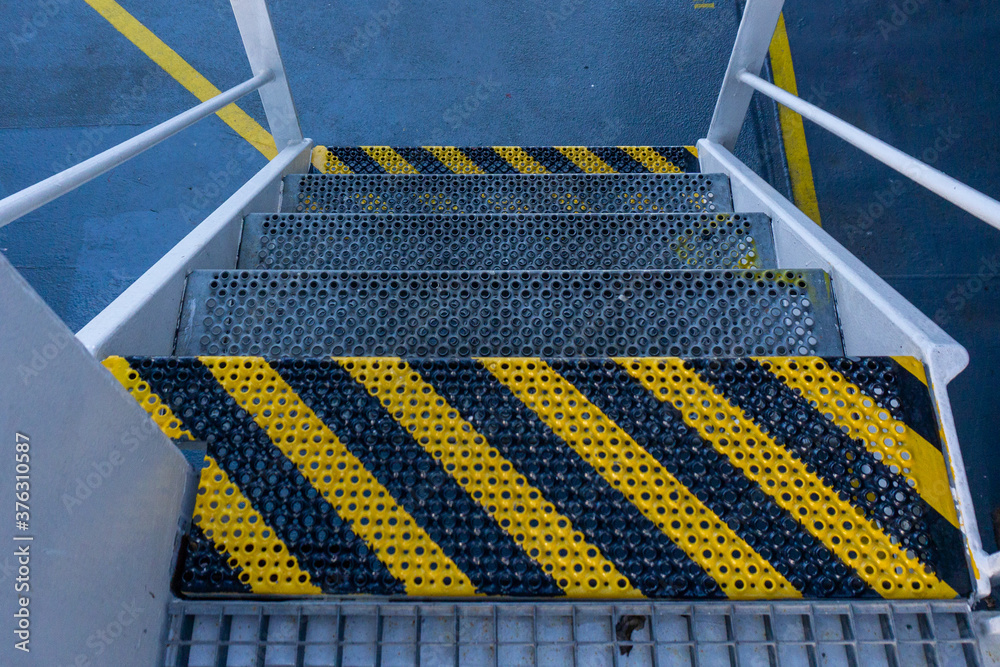 Fototapeta premium Ships stairs / stairway. First step off stairway painted in yellow black. Ships anti-slip stairs.