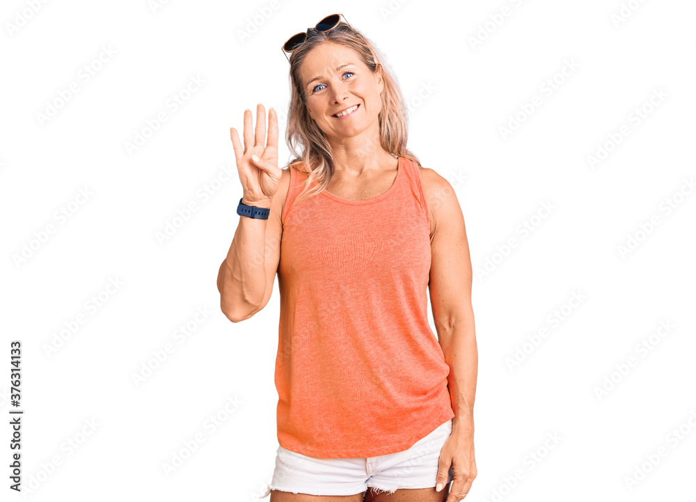 Middle age fit blonde woman wearing casual summer clothes and sunglasses showing and pointing up with fingers number four while smiling confident and happy. Middle age fit blonde woman wearing casual summer clothes and sunglasses showing and pointing up with fingers number four while smiling confident and happy.