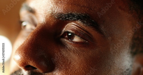 фотографія Close up of young face of happy African American man with sweat drops on skin looking at side