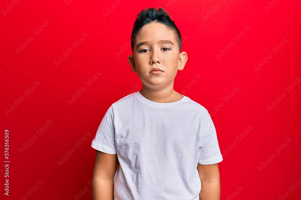 Little boy hispanic kid wearing casual white tshirt with serious expression on face. simple and natural looking at the camera. Little boy hispanic kid wearing casual white tshirt with serious expression on face. simple and natural looking at the camera.