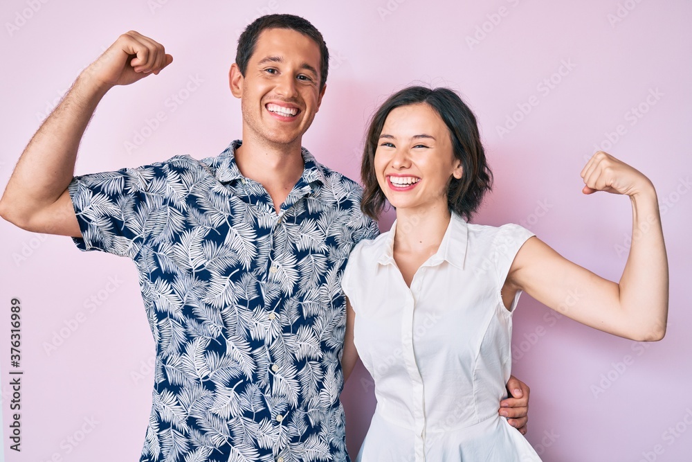 Beautiful couple wearing casual clothes showing arms muscles smiling proud. fitness concept. Beautiful couple wearing casual clothes showing arms muscles smiling proud. fitness concept.