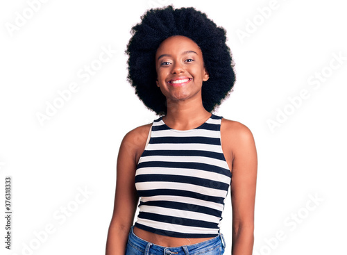 Young african american woman wearing casual clothes looking positive and happy standing and smiling with a confident smile showing teeth