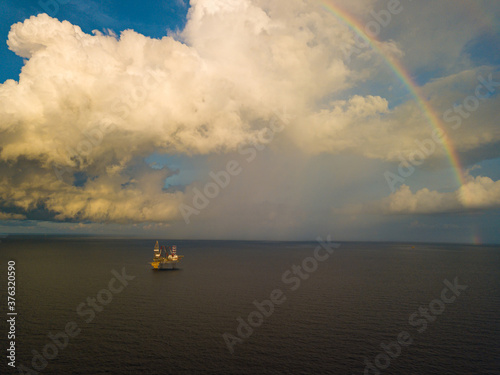 Aerial view from a drone of an offshore jack up rig at the offshore location during raining time with rainbow