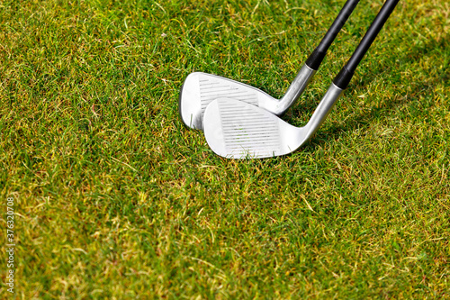 Golf clubs on the green grass