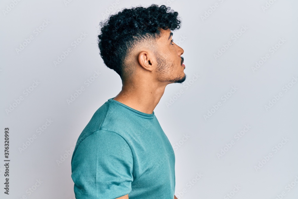 Young arab handsome man wearing casual clothes looking to side, relax profile pose with natural face with confident smile. Young arab handsome man wearing casual clothes looking to side, relax profile pose with natural face with confident smile.