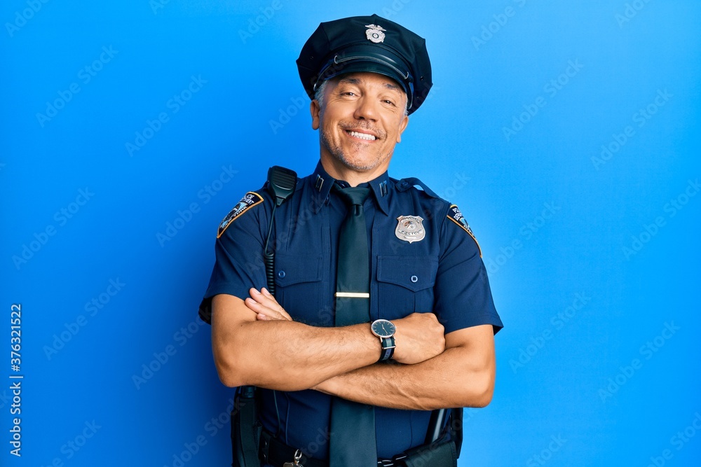 Handsome middle age mature man wearing police uniform happy face smiling with crossed arms looking at the camera. positive person. Handsome middle age mature man wearing police uniform happy face smiling with crossed arms looking at the camera. positive person.
