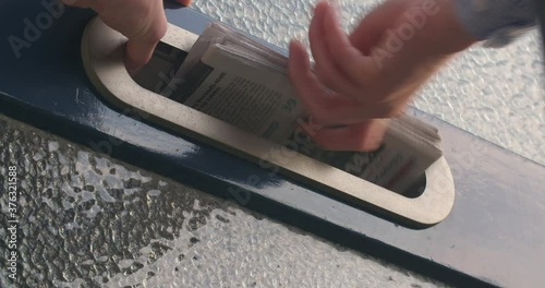Rotterdam, The Netherlands - September 01 2017: Closeup shot of a home mailbox receiving a newspaper.