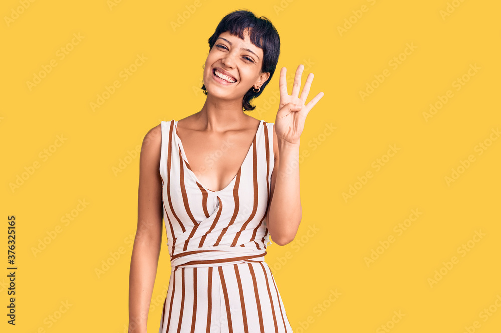 Young brunette woman with short hair wearing summer outfit showing and pointing up with fingers number four while smiling confident and happy. Young brunette woman with short hair wearing summer outfit showing and pointing up with fingers number four while smiling confident and happy.