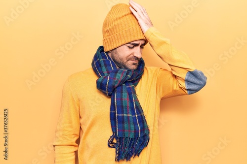 Young handsome bald man wearing winter clothes surprised with hand on head for mistake  remember error. forgot  bad memory concept.