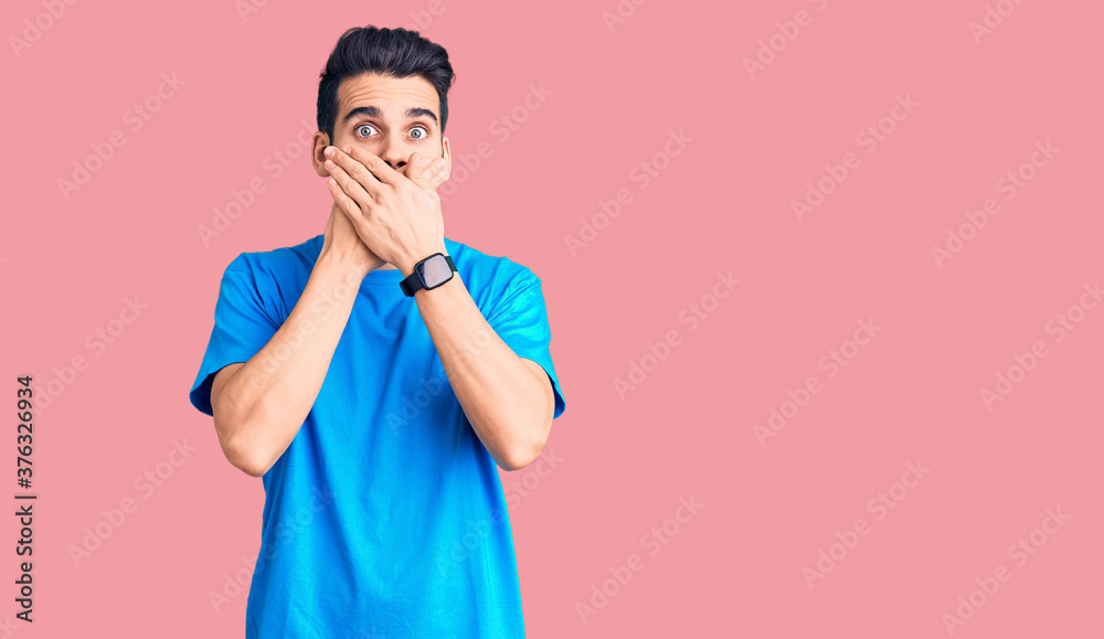 Young handsome man with beard wearing casual t-shirt shocked covering mouth with hands for mistake. secret concept. Young handsome man with beard wearing casual t-shirt shocked covering mouth with hands for mistake. secret concept.