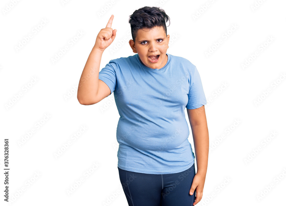 Little boy kid wearing sports workout clothes pointing finger up with successful idea. exited and happy. number one. Little boy kid wearing sports workout clothes pointing finger up with successful idea. exited and happy. number one.