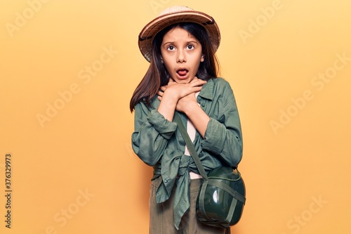 Beautiful child girl wearing explorer hat shouting and suffocate because painful strangle. health problem. asphyxiate and suicide concept. photo