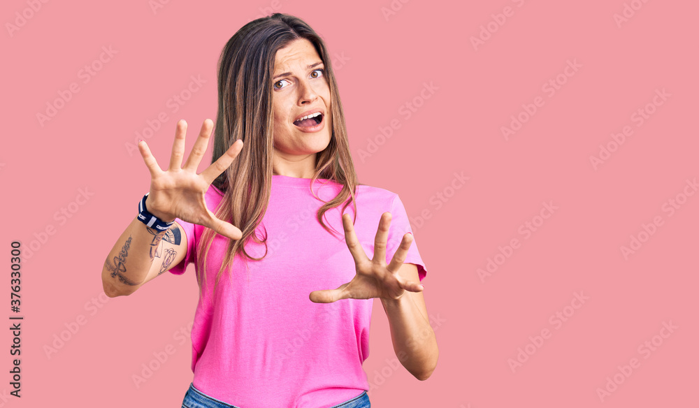 Beautiful caucasian woman wearing casual clothes afraid and terrified with fear expression stop gesture with hands, shouting in shock. panic concept. Beautiful caucasian woman wearing casual clothes afraid and terrified with fear expression stop gesture with hands, shouting in shock. panic concept.
