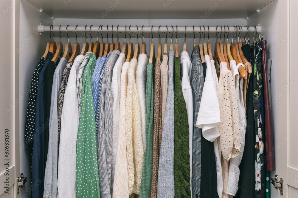 Clothes on a rail in a wardrobe. Seasonal capsule for easy dressing, order in things, cleaning out Clothes on a rail in a wardrobe. Seasonal capsule for easy dressing, order in things, cleaning out
