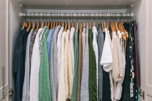 Clothes on a rail in a wardrobe. Seasonal capsule for easy dressing, order in things, cleaning out