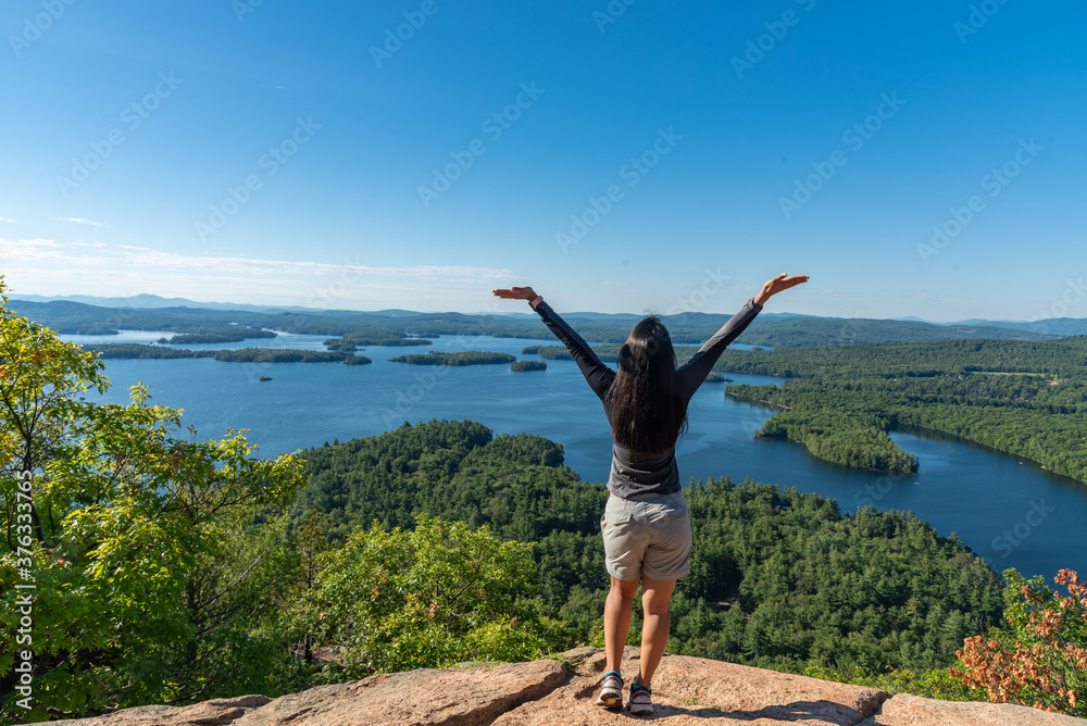 Woman enjoying the view of Squam lake from West Rattlesnake Mountain New Hampshire Woman enjoying the view of Squam lake from West Rattlesnake Mountain New Hampshire