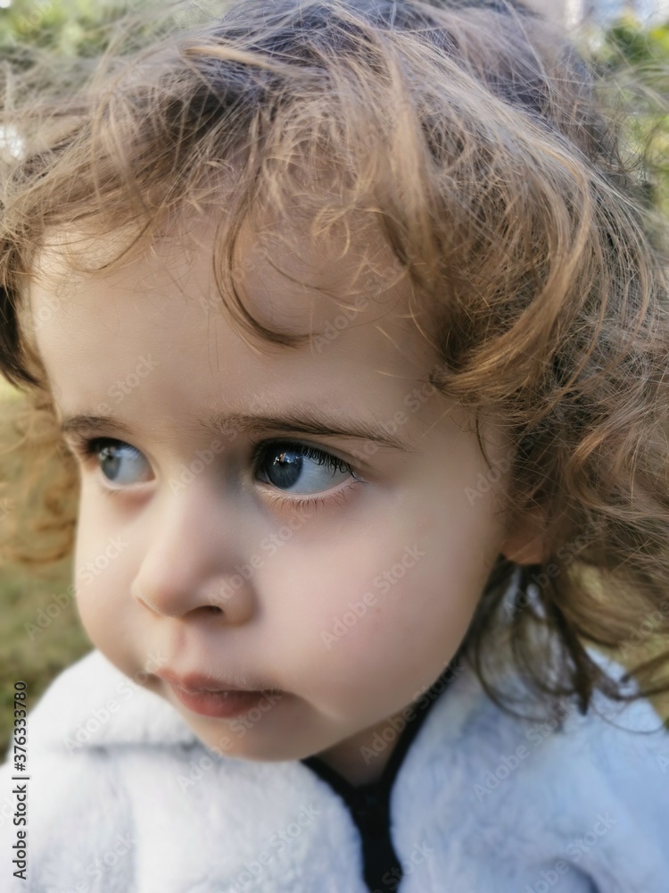 Close of Little Brazilian girl looking to the side outdoors Close of Little Brazilian girl looking to the side outdoors