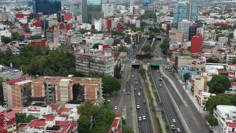 Vista aérea sobre el Viaducto Miguel Aleman, con autos en circulando en ambos sentidos, y el Ecoducto Río Becerra. El drone volando de forma lateral y con tráfico en amb