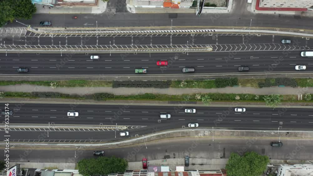 Vista aérea cenital, el drone descendiendo lentamente, sobre el Viaducto Miguel Alemán con tráfico pesado en ambos sentidos