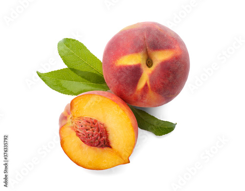 Whole and cut ripe peaches with leaves isolated on white, top view