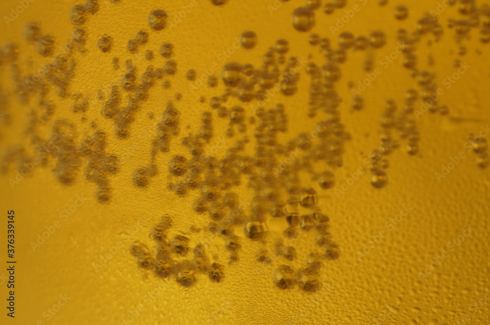 Wet glass of beer, golden color in the dark Wet glass of beer, golden color in the dark