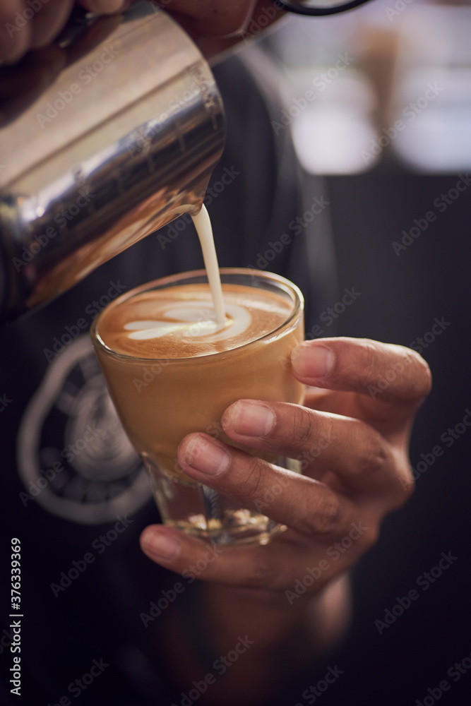 Barista making cup of coffee latte in coffee shop in close up style Barista making cup of coffee latte in coffee shop in close up style