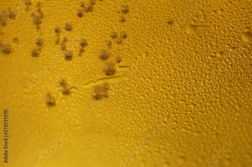 Wet glass of beer  golden color in the dark