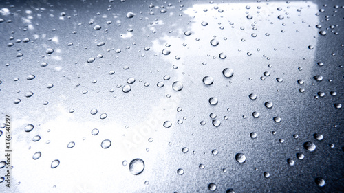 Gray automobile surface texture with rain droplets