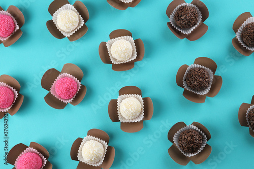 Brigadeiro, handmade chocolate candy, strawberry candy and coconut candy on blue background