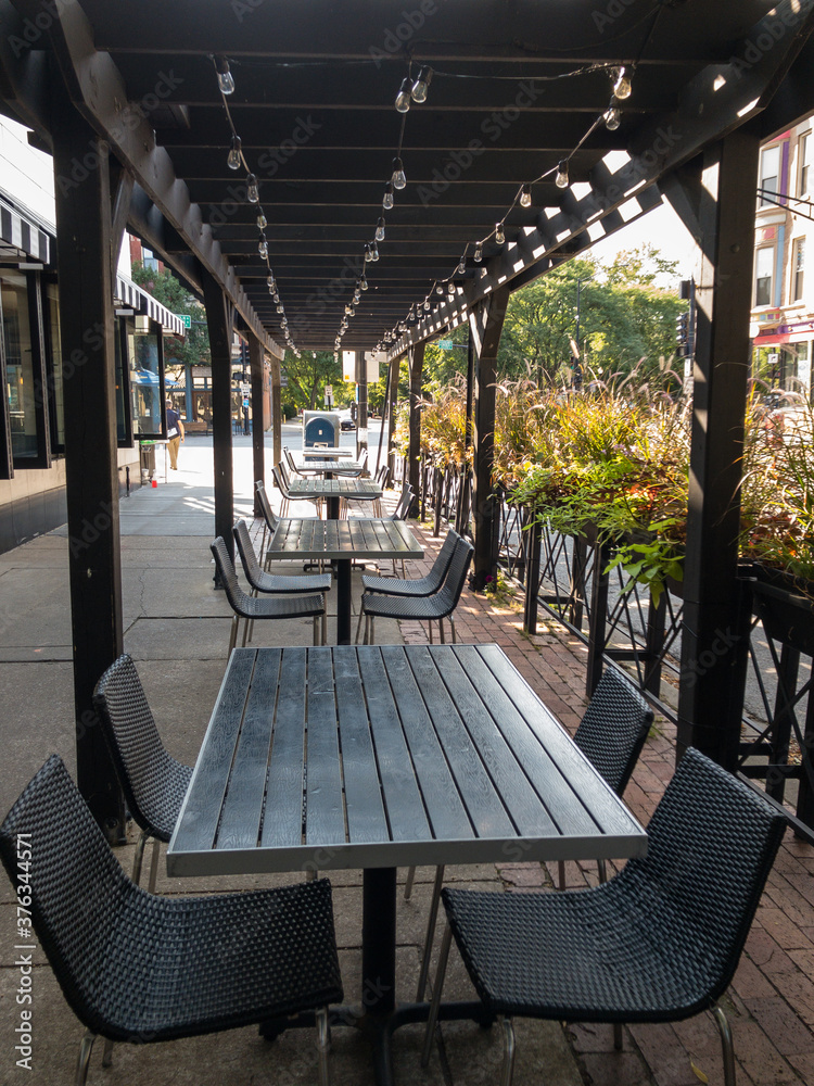 empty covered outdoor restaurant patio seating in city