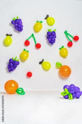 stylish baby girl in a fashionable sun visor, jumping on a fruit background.