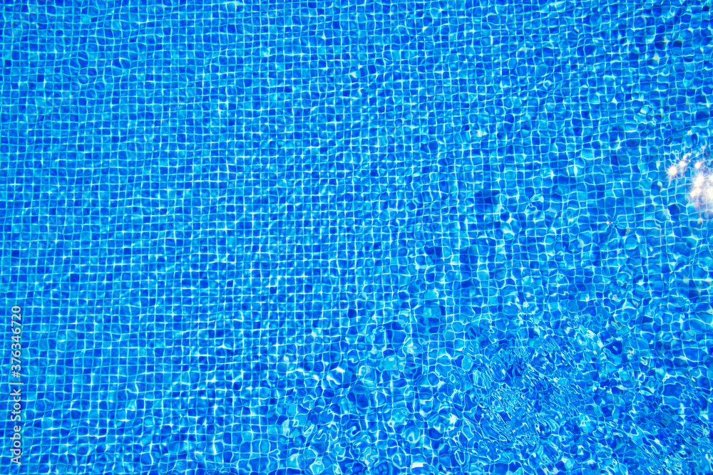 Top view of clear water in a blue tile pool background. Ripple effect Top view of clear water in a blue tile pool background. Ripple effect