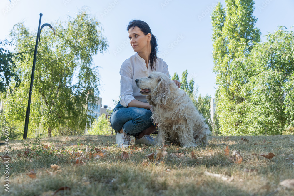 Old dog spaniel sitting with owner young woman at walk outdoor. Old dog spaniel sitting with owner young woman at walk outdoor.