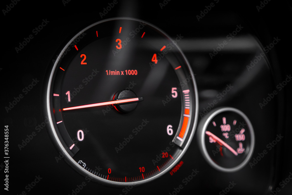 dashboard of the car is illuminated by bright  circle tachometer.