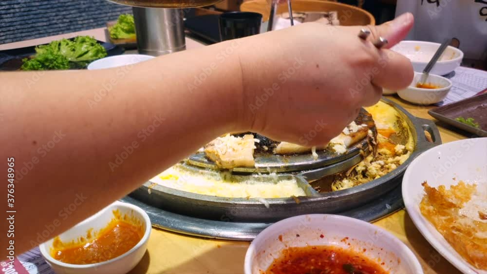 Korean hot plate barbeque with various cuts of meat and melting cheese