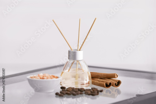 Reed diffuser, cinnamon, sea salt and coffee beans on table