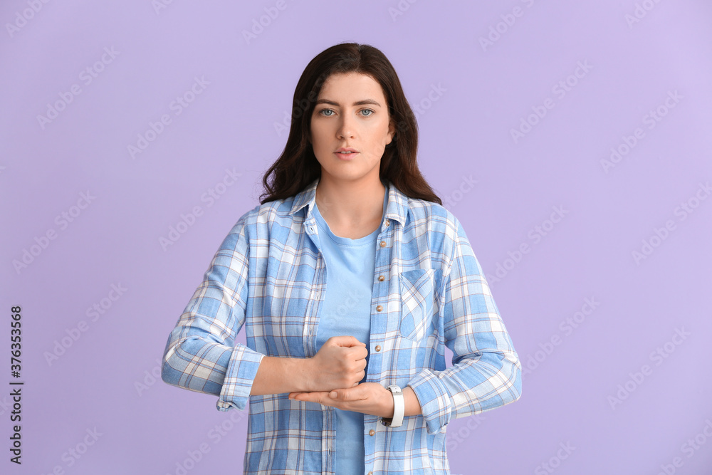 Young deaf mute woman using sign language on color background Young deaf mute woman using sign language on color background