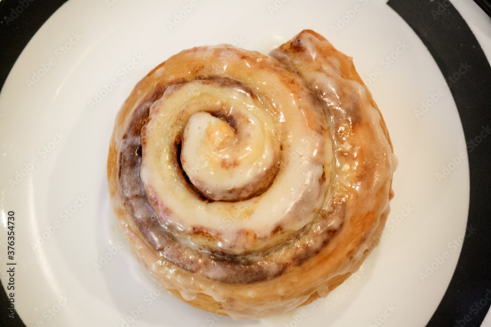 Fototapeta premium Delicious hot cinnamon roll with icing