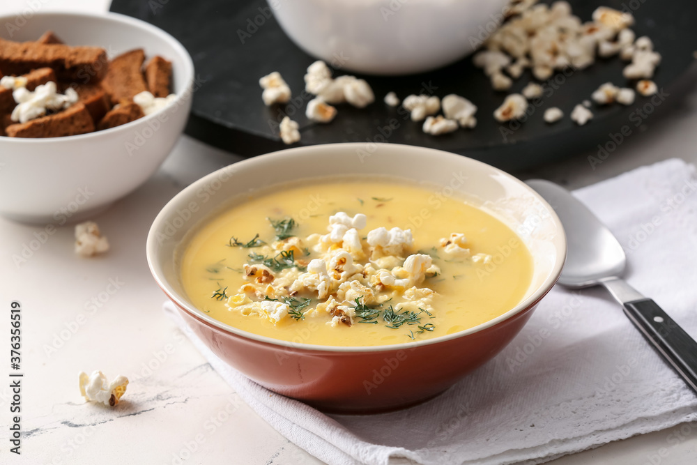 Bowl with tasty popcorn soup on table