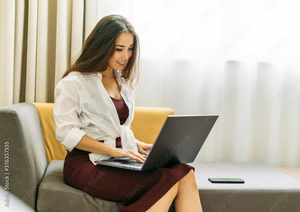 Beautiful smiling asian young woman with long hair working on laptop in the hotel room Beautiful smiling asian young woman with long hair working on laptop in the hotel room