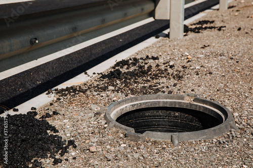 An open sewer hatch that poses a danger to people who walk along the city street. No manhole covers. Repair work