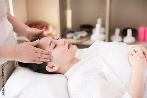 Young Asian woman getting spa massage treatment at beauty spa salon. Face massage, Relaxing massage, Spa skin and body care