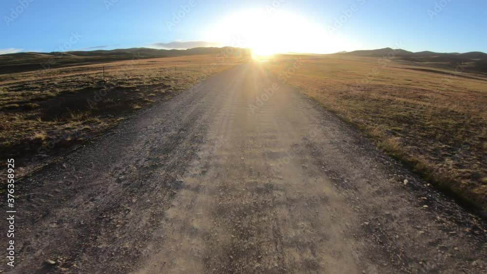 Driving on high altitude dirt trail in sunset Driving on high altitude dirt trail in sunset