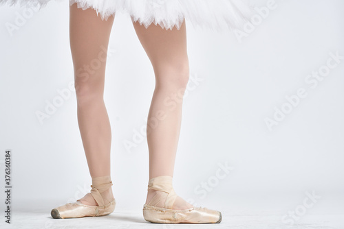 Ballerina in a white tutu dance performed on a light background