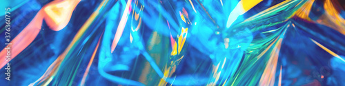 Abstract iridescent blue orange and blue fluid liquids reflections background with lens flare soft focus. Trending colors festive background for greeting card or blog banner
