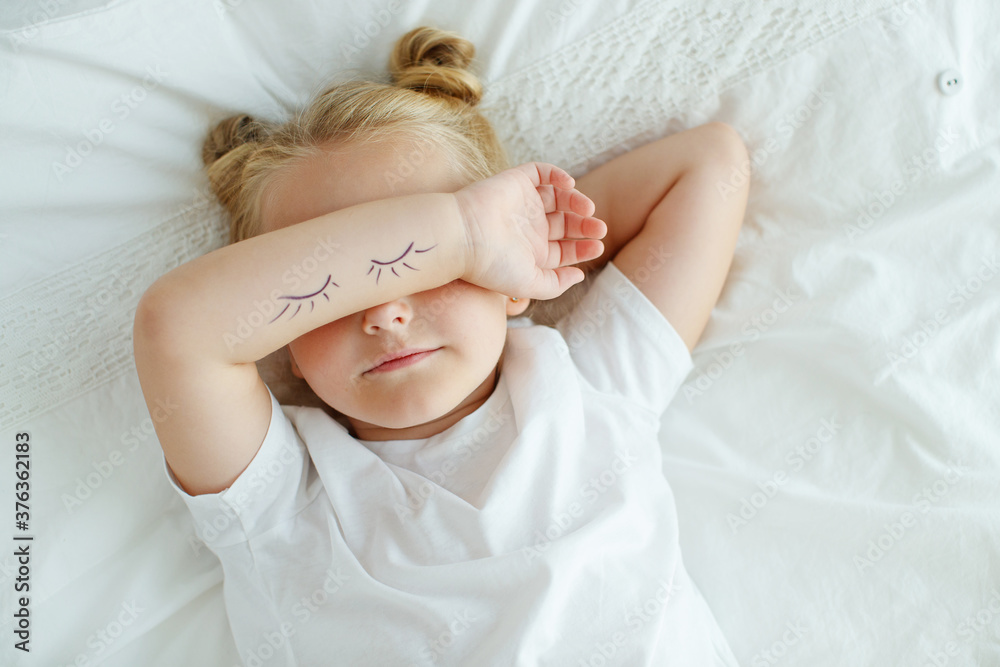 Little girl in bed with white linen. A child at home in the morning wakes up in his room. High quality photo. Little girl in bed with white linen. A child at home in the morning wakes up in his room. High quality photo.