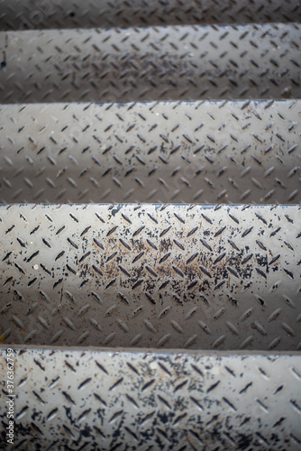 Steel steps painted white, old, slightly rusted.