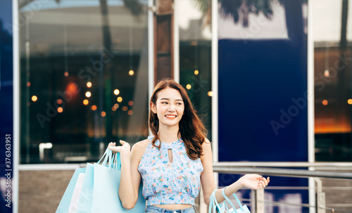 Canvas Print Young adult asian woman with shopping bag indoor background on day