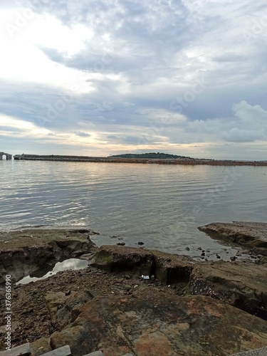 Beach view at sunset with cloudy sky