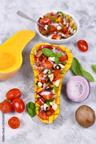Vegan baked Butternut squash filled bell pepper, cherry tomatoes, red onion and mushrooms